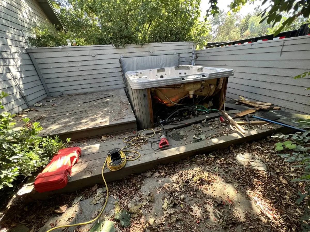 Hot tub shell on a backyard patio during a spa removal